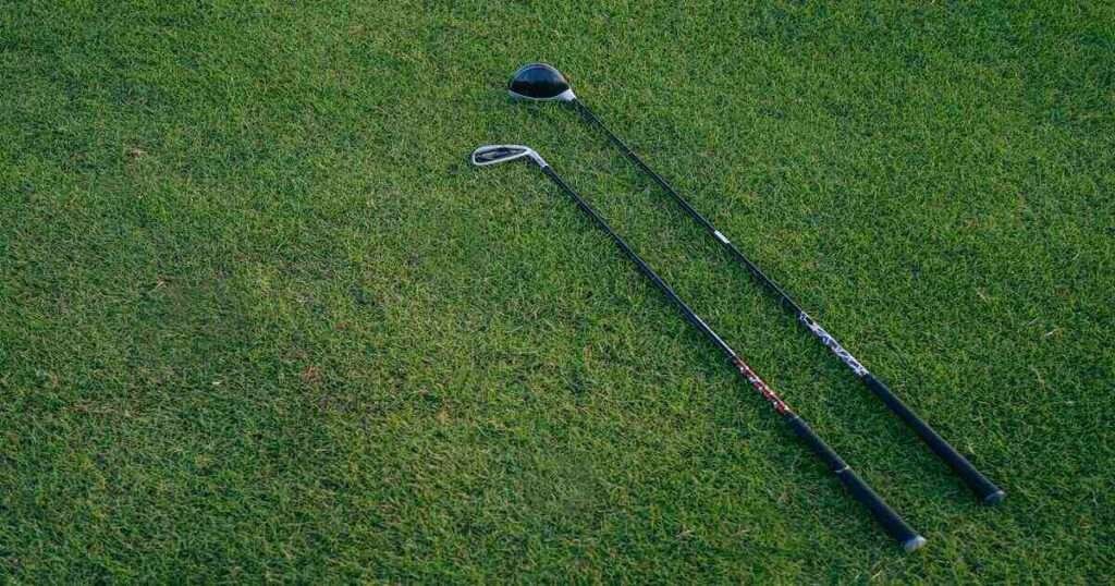 Golf club laid on a grass which visulise 40 inches in length