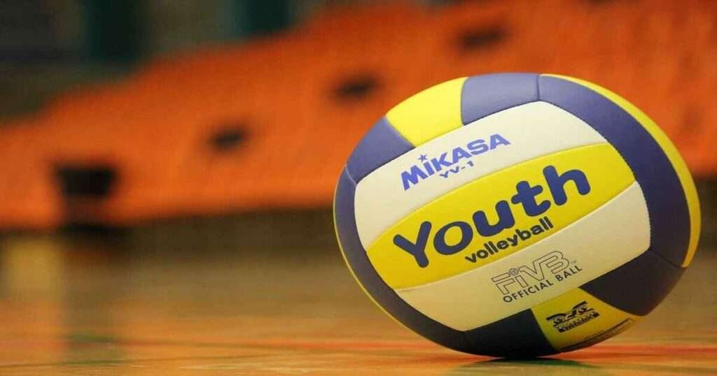 Close-up of a Mikasa volleyball stack five to visulize 40 inches on a glossy gym floor.